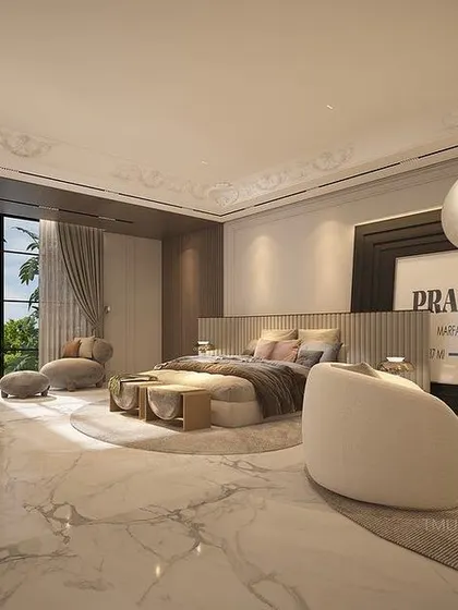 We designed this expansive bedroom with a palette of soft neutrals and whites, set against a gleaming marble floor. The space includes a lounge area with statement art and a dedicated study nook, creating a complete, self-contained suite.
