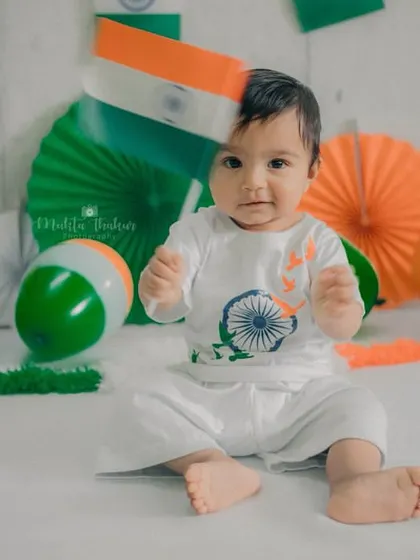 A playful moment where the baby has put the flag on his head. It's a funny and candid memory that shows the real fun of the session.