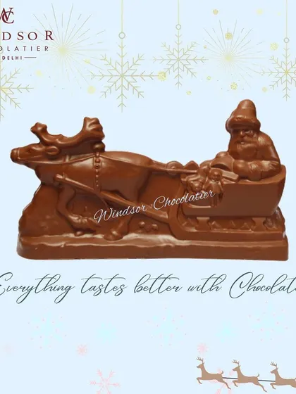 This large, solid chocolate sculpture depicts Santa Claus on his sleigh, pulled by a reindeer. It's a classic Christmas scene brought to life in delicious milk chocolate.