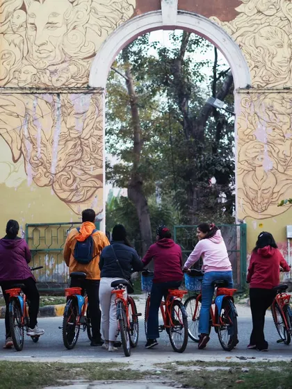 Our riders pause at one of the green gates leading into the residential blocks of Lodhi Colony, framed by beautiful artwork.