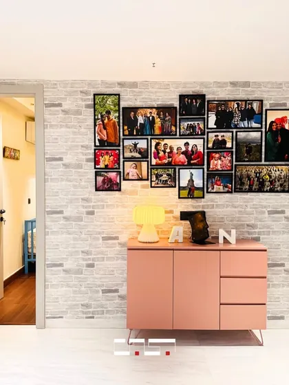 A personal touch is added to this hallway with a gallery wall of family photos above a stylish pink console, turning a simple passage into a wall of memories.