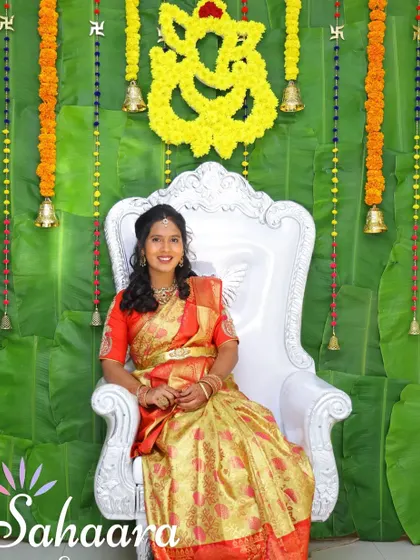 A classic and traditional baby shower setup. The backdrop of fresh banana leaves, marigold garlands, and brass bells creates an auspicious and beautiful setting for the mother-to-be.