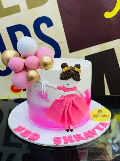 A modern 2kg cake with a pink watercolor effect, featuring a fondant girl holding a bouquet of balloons.