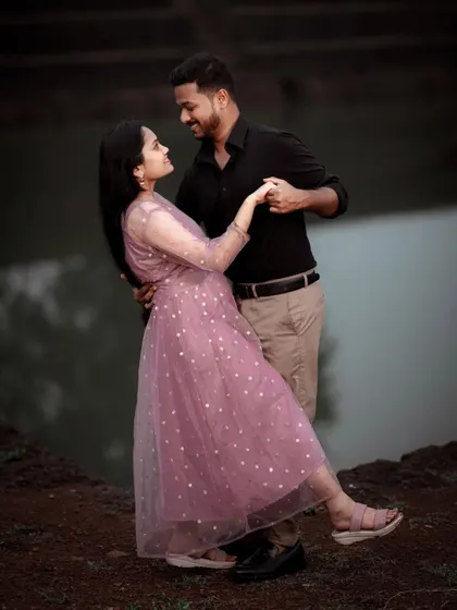 A couple shares a romantic dance by the water's edge, their pose elegant and full of love, perfect for a pre-wedding album.