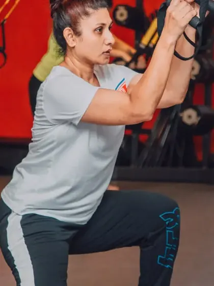 A member demonstrates excellent form during a TRX lunge. This exercise is fantastic for building lower body strength, stability, and balance.