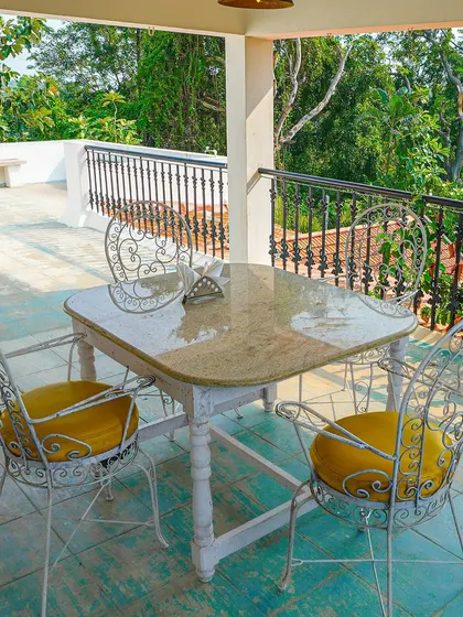 Enjoy a meal with a view. This outdoor seating area on the villa's balcony overlooks the resort's greenery, providing a refreshing dining experience for your team.
