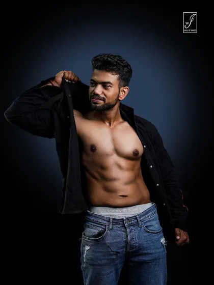 Capturing a moment of movement, as if the subject is putting on or taking off his shirt. This adds a candid, lifestyle feel to the fitness shoot while still highlighting the core and chest.