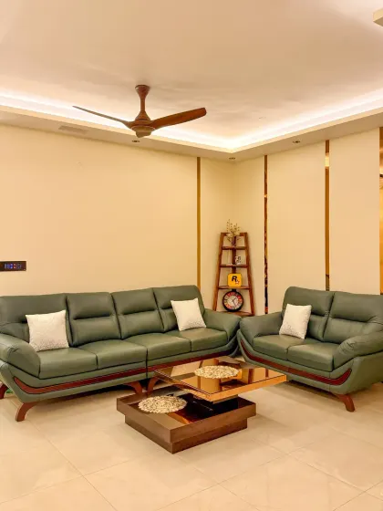 A full view of a living room we automated, showcasing the clean integration of our smart panel on the wall and the beautiful effect of the automated ceiling lights.