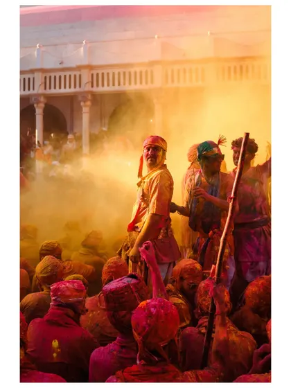 A man stands amidst a cloud of yellow powder, illuminated by a ray of sunlight. These moments of dramatic lighting within the chaos are what I constantly search for.