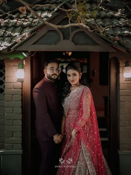 A classic portrait of the couple standing in a rustic doorway, ready to celebrate their union with friends and family.