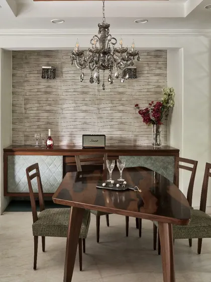 At The Classic Modern Storey, this dining area reclaims the joy of gathering. The boomerang-inspired table is crafted to encourage shared meals, while the classical chandelier adds a touch of elegance, balancing contemporary and timeless design.