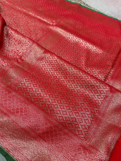 A closer look at the rich red pallu of a Banarasi silk saree, showcasing the intricate diamond jaal weaving in gold zari.