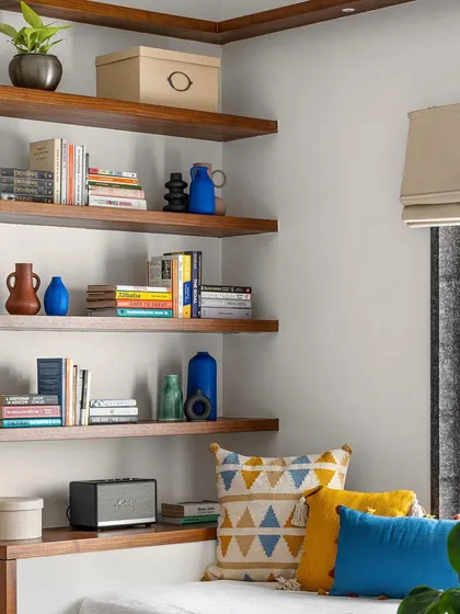 A cozy reading nook with a platform seat and floating wooden shelves, perfect for a family lounge.