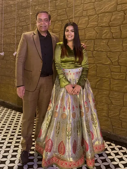 With my father at a family function. I've paired a modern olive green satin top with a traditional brocade lehenga skirt for a unique fusion look.