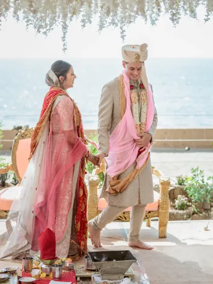 A candid moment from the wedding ceremony, with the couple walking around the sacred fire. The groom's happy, slightly shy expression is a wonderful, genuine detail.