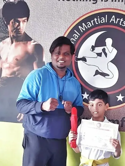This student receives his red belt, a junior black belt rank that signifies a high level of skill.