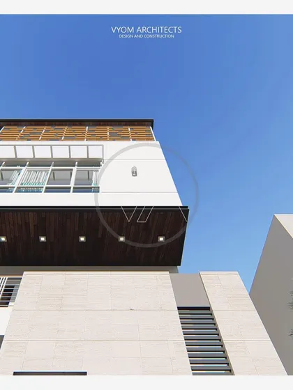 An upward angle of the Vishal residence, emphasizing the clean lines of the roof overhang and the texture of the wooden screen on the top floor terrace.