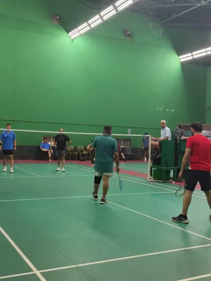 Players getting ready to receive a serve during a competitive but friendly doubles game.