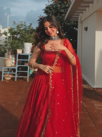 A happy, sun-kissed shot of the client in her red lehenga.
