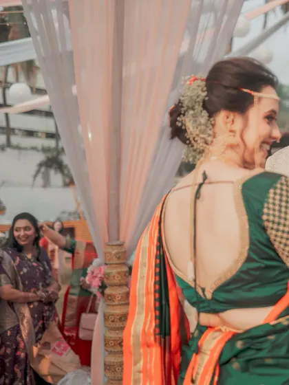 A beautiful shot of the bride from behind, highlighting the elegant design of her blouse and her traditional hairstyle. We pay close attention to the details of bridal fashion.