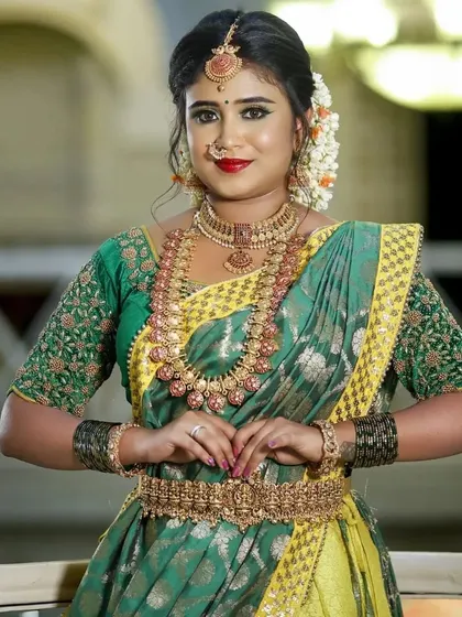 A happy bride in a vibrant green and yellow saree, complemented by our traditional jewellery. This is a perfect look for a festive pre-wedding event.