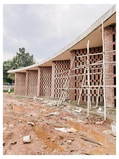Duplicate of the curved brick facade with scaffolding.