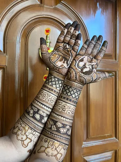 A clear shot of the full two-arm design against a wooden door, highlighting the rich henna paste.