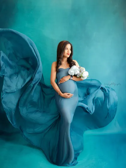 Like a goddess of the sea. This portrait uses a flowing blue gown and a matching backdrop to create a dramatic, ethereal, and truly unforgettable image.