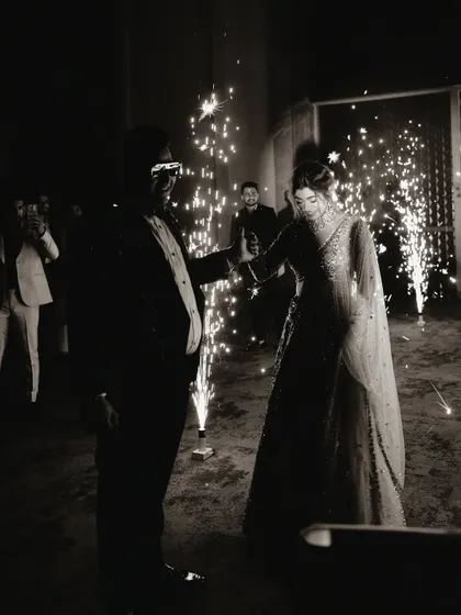 A magical entrance for the bride and groom, surrounded by sparklers. This black and white photo beautifully captures the celebratory mood of a reception party.