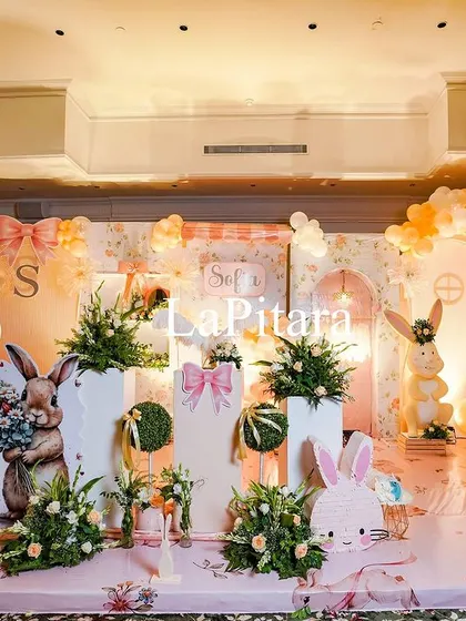 The main stage for the high-tea party, featuring a soft peach color palette, cherry blossom trees, and adorable bunny props.