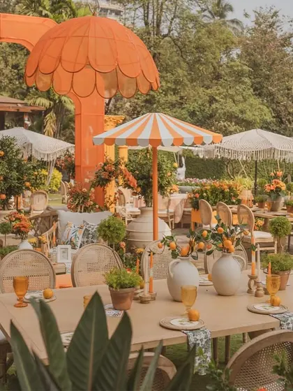 A wide view of the dining area, featuring a mix of custom umbrellas and lush floral arrangements.