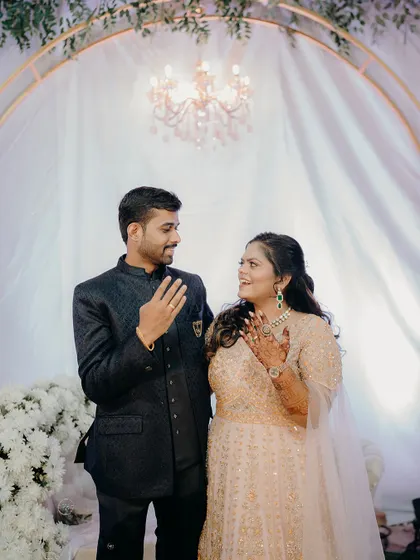 The couple proudly showing their engagement rings to each other. A simple, happy moment that signifies their commitment.