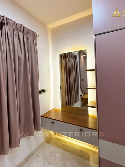 A compact dressing table with a backlit mirror, seamlessly integrated next to a large wardrobe. The design is perfect for optimizing space in a bedroom.