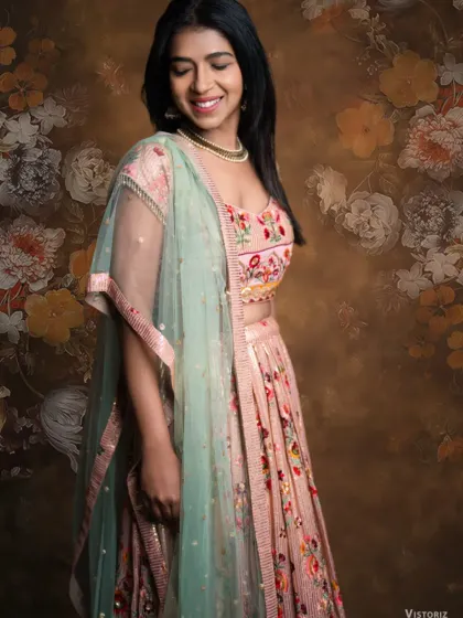 A smiling portrait of our client looking radiant in the floral embroidered lehenga. The craftsmanship and colors are designed to make you feel your best.