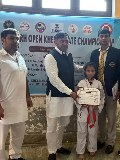 This young girl, a red belt, proudly holds her achievement certificate after the competition.