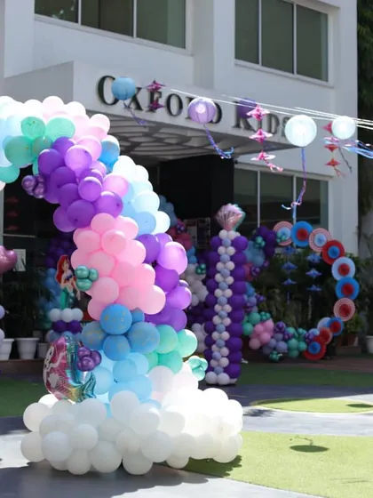 The grand entrance to the Mermaid party, featuring a massive balloon rainbow arch resting on clouds. It creates a magical pathway into the underwater celebration.