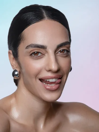 A playful and confident shot. The clean, glowing skin and simple hair keep the look feeling fresh and modern.