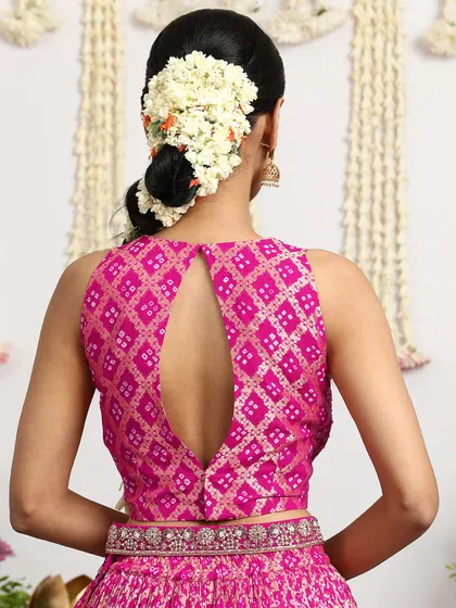 The back of the Bandhani blouse features an elegant keyhole design, adding a touch of modern sophistication to this traditional ensemble.