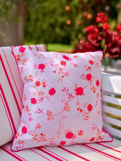 A custom-printed cushion with the pomegranate motif, adding a personalized touch to the lounge seating.