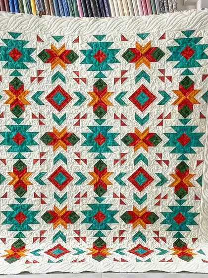 A beautiful quilt with a Southwestern-inspired geometric pattern. The combination of teal, orange, and red creates a vibrant and balanced design.