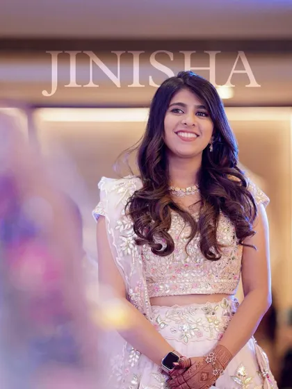 A glowing and happy wedding guest. Her makeup is soft and natural, with a focus on a radiant complexion that shines in the photo.