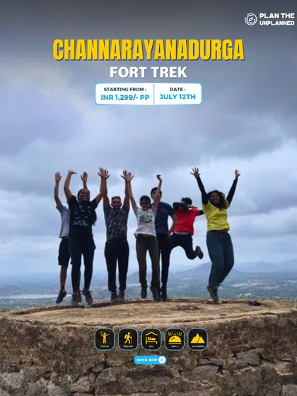 A group jumps for joy on top of a bastion at Channarayanadurga Fort. The panoramic views from the top are worth every step.