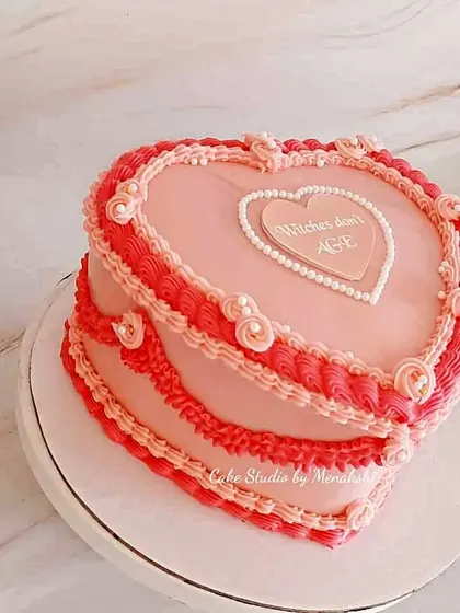 A stunning vintage heart-shaped cake. The intricate piping and soft pink colors give it a beautiful, old-fashioned charm.