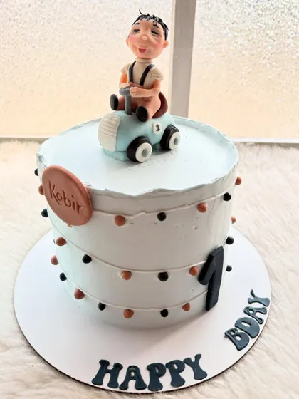 Vrooming into year one with this cute car-themed cake. The design is simple and modern, with a hand-sculpted little boy in his first car.