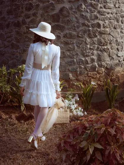 This image from the 'White Rose' editorial shows the full look in a rustic garden setting. I styled this tiered white dress with a contrasting belt and vintage-inspired heels to tell a story of timeless romance and elegance.