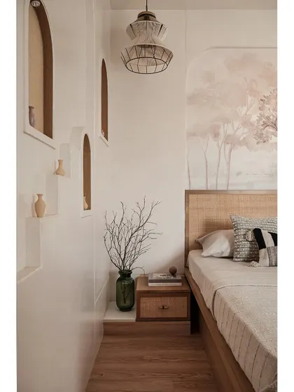 This view highlights the arched wall niches with cane detailing and micro-topped walls, which create a beautiful focal point. The layered textures and earthy tones give the master bedroom a calm, natural feel.