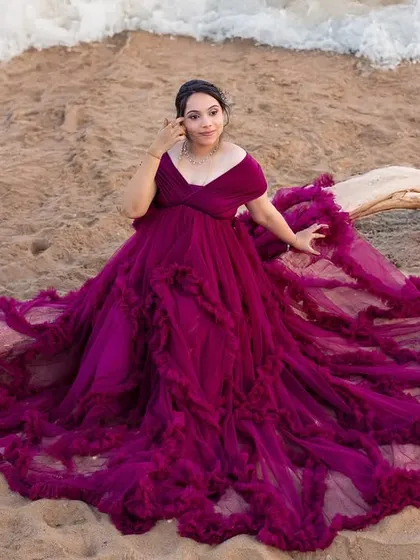 An aerial view of the mom-to-be lying on her gorgeous purple gown, creating a beautiful, artistic composition on the sand.
