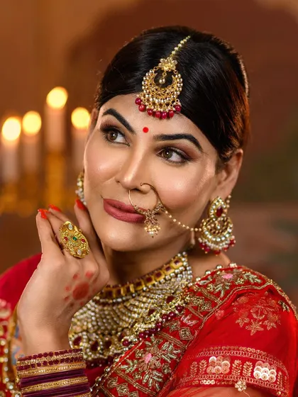A detailed close-up of the Jodhabai look, highlighting the specific Mughal-style jewelry, including the maang tikka, nath, and heavy choker, complemented by flawless makeup.