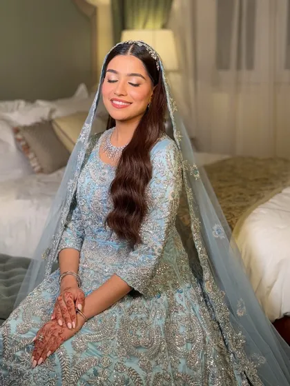 A serene moment of bridal bliss. The soft veil and gentle smile are paired with makeup that is equally soft and dreamy, perfect for a Nikah or reception.