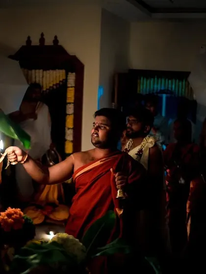 An atmospheric shot of a priest performing a ritual in low light. We are skilled at capturing the mood and solemnity of the wedding ceremony.